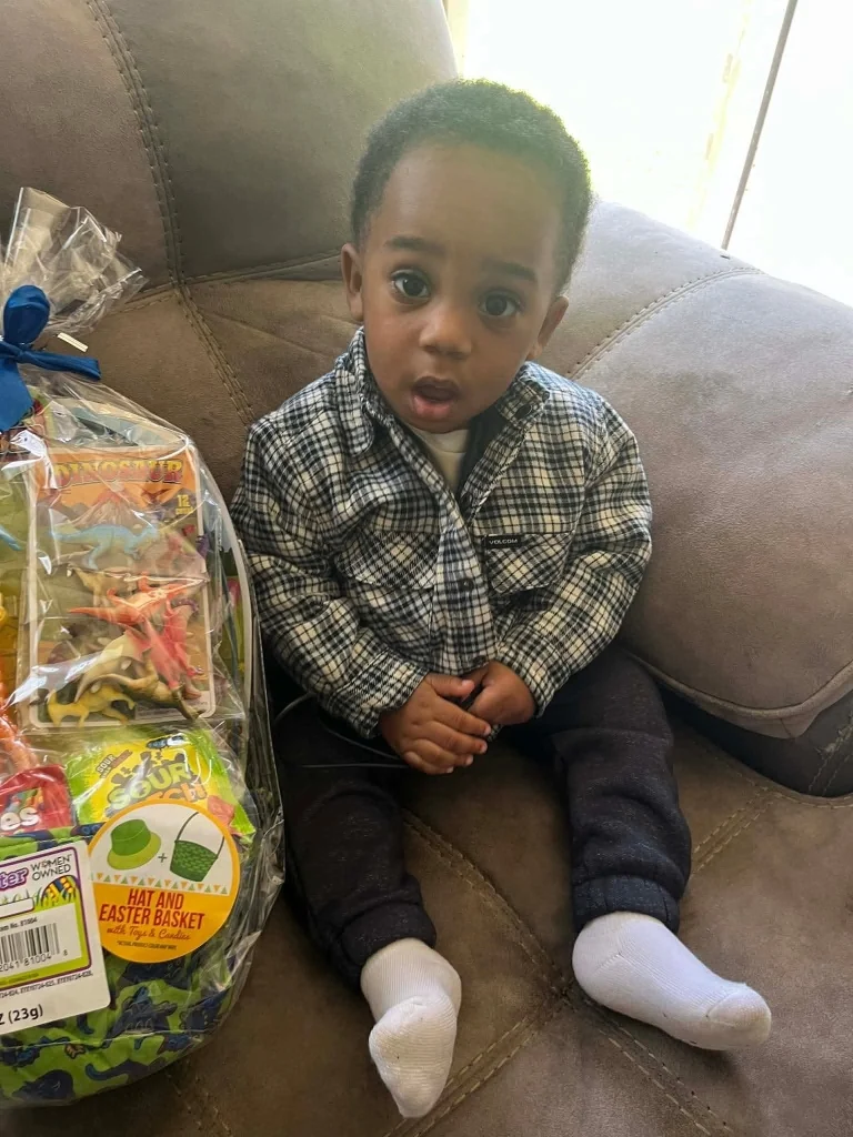 Kohen Kartier Wiley seated beside an Easter basket